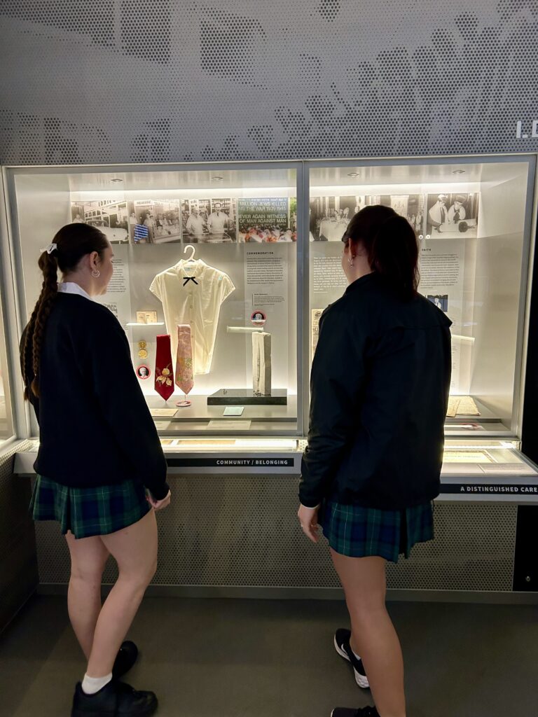Students examining display of Holocaust artefacts.