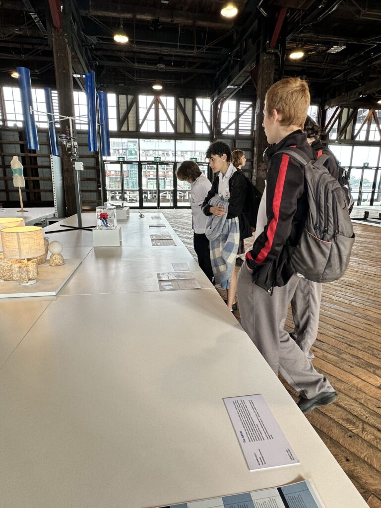 Students gathered, intently looking at example projects