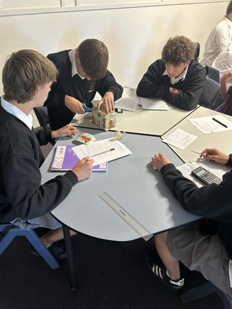Students demonstrated teamwork and precision while solving real-world surface area minimisation challenges.