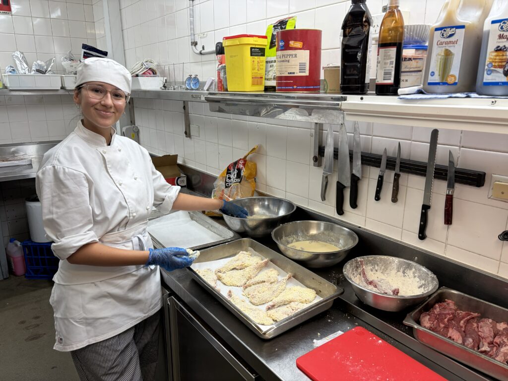 Applying industry techniques with confidence, this student excels in hands-on food preparation.
