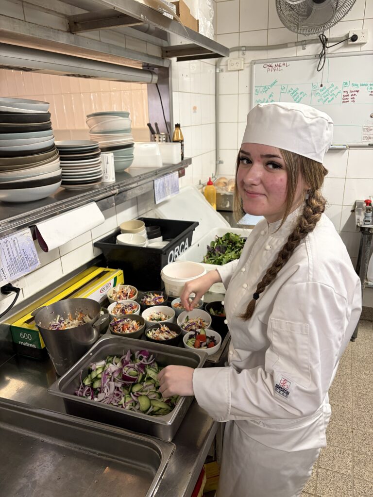 Creativity and teamwork shine as this student prepares fresh dishes with care.