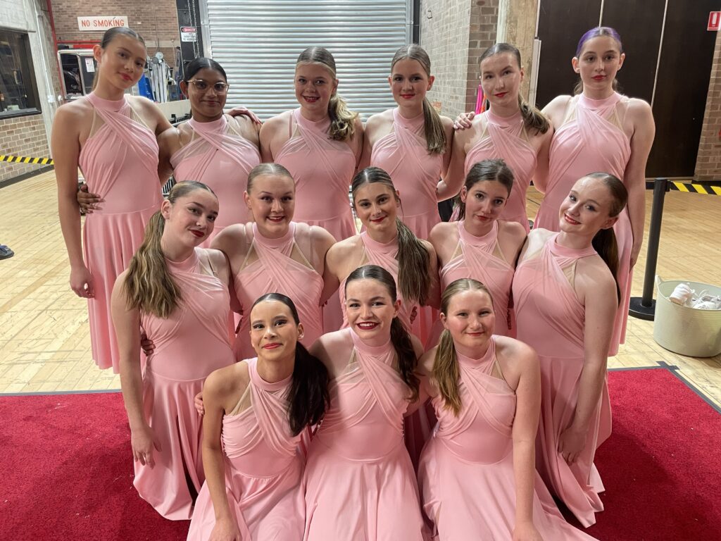 Proud Gymea Technology dancers celebrate an outstanding performance with confidence, unity, and smiling success.